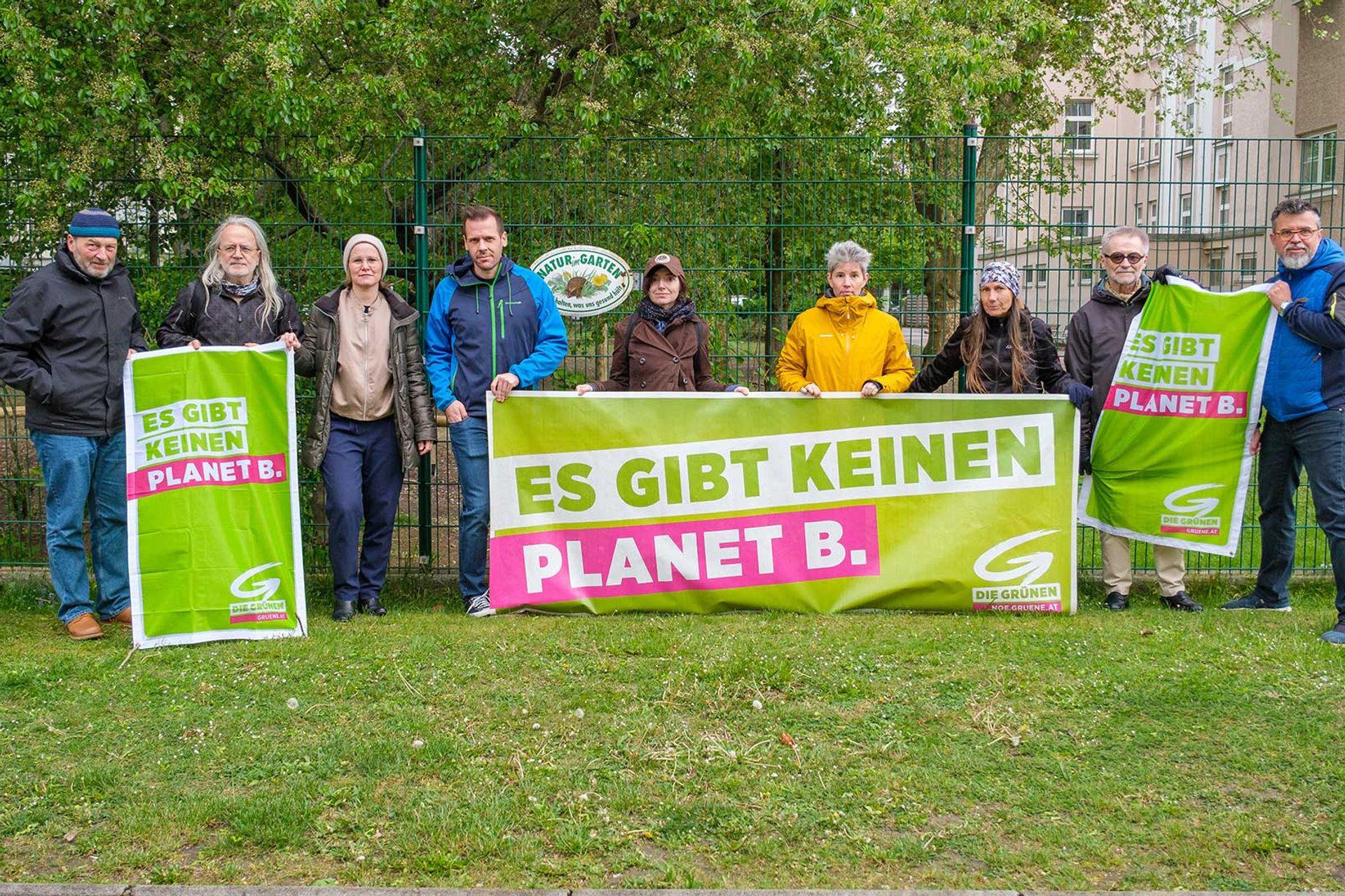 Das Grüne Team mit Transparenten vor dem Schulgarten