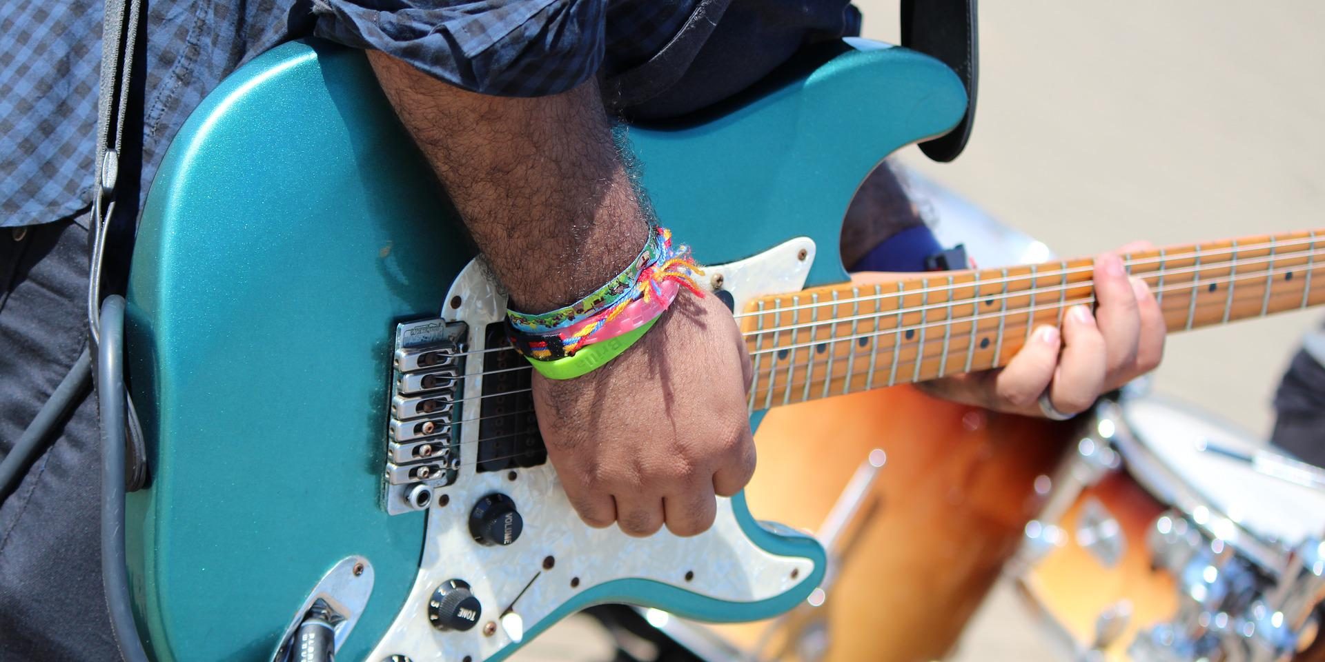 Detailaufnahme einer E-Gitarre, die von einem Musiker gespielt wird