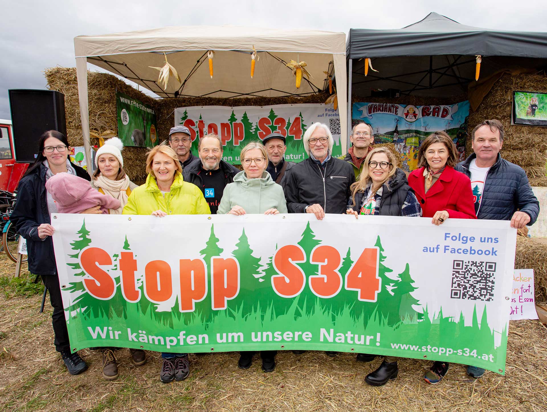 Personengruppe mit Transparent vor dem mit Heuballen improvisierten Podest
