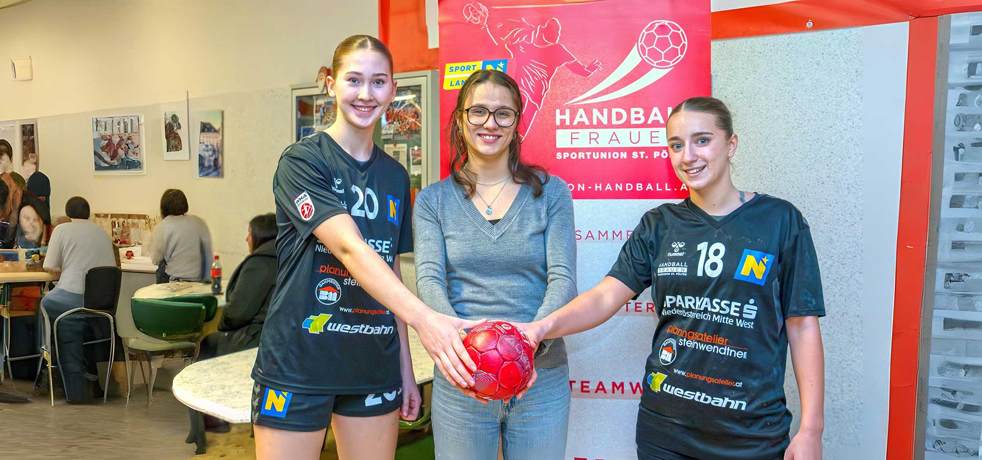 2 junge Handballerinnen und Grün-Kandidatin Lisa Koban vor Siegerehrungswand