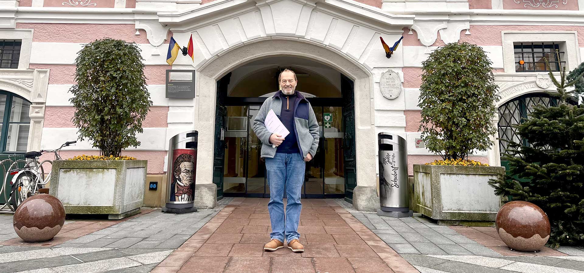 Ein Mann präsentiert das Wahldokument vor dem Rathaus von St. Pölten
