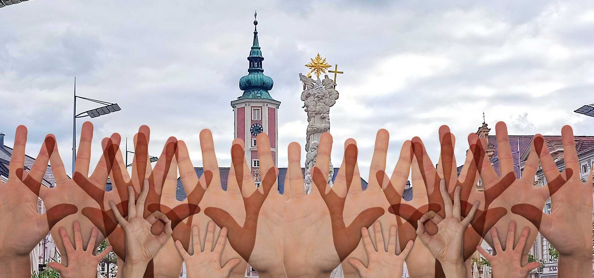 Viele Hände werden in die Höhe gereckt vor dem Rathaus St. Pölten