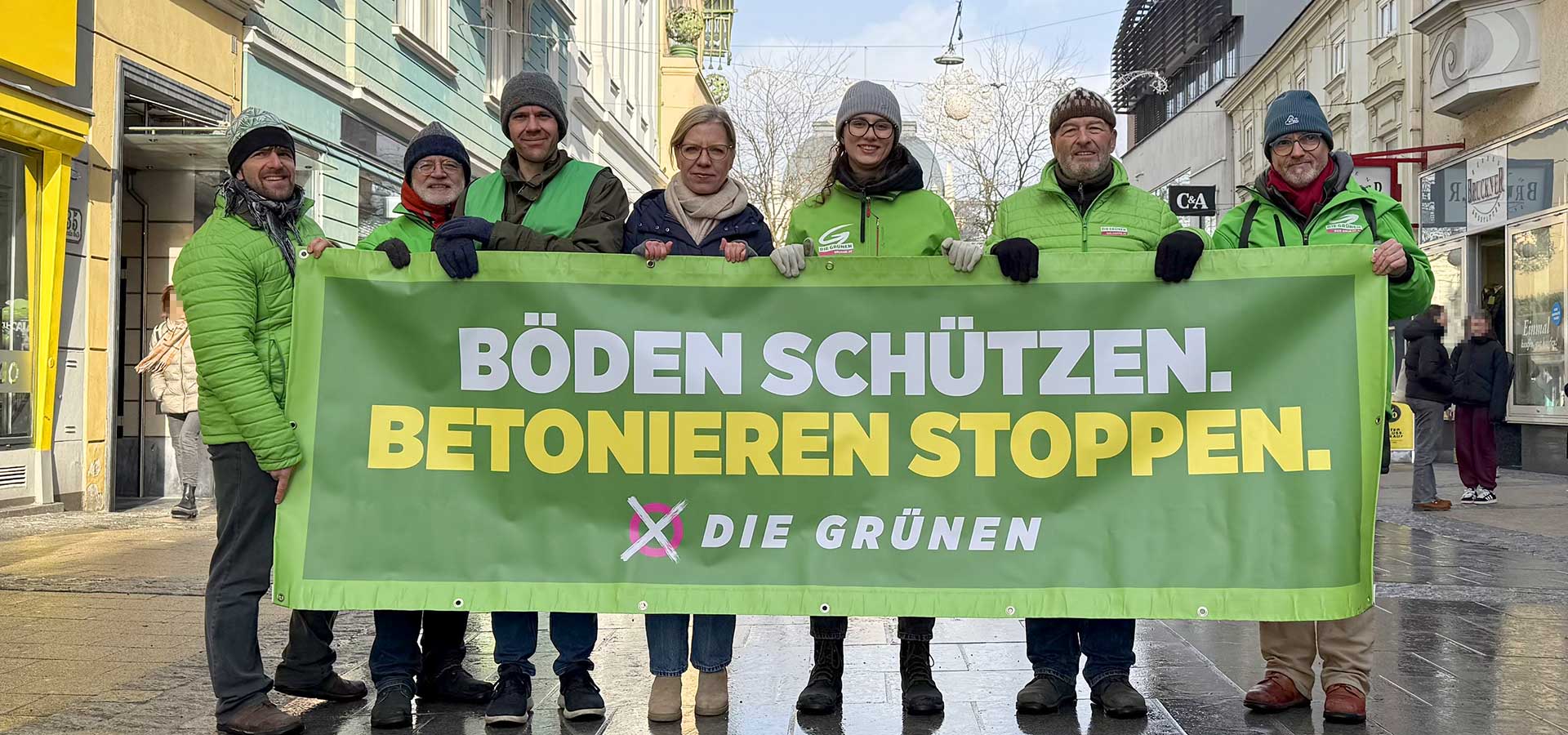Grüne Aktivist:innen und Parteichefin Gewessler fordern in der St. Pöltner Innenstadt mit einem Transparent einen Stopp der Bodenversiegelung
